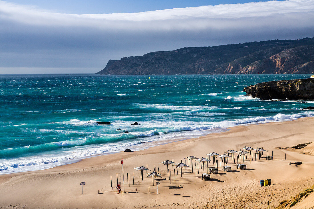 Ocean waves crashing on the sandy beach and bathhouse of Cascais surrounded by cliffs Estoril Coast Lisbon Portugal Europe