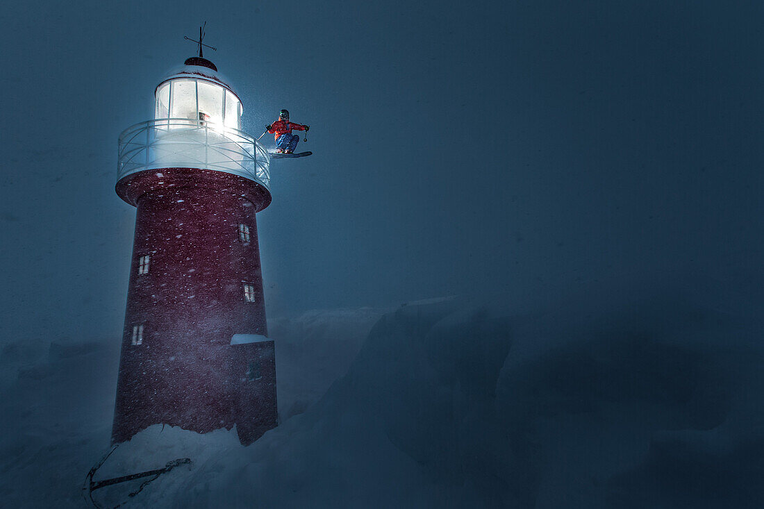 Young male skier jumping at a lighthouse in the deep snow, Andermatt, Uri, Switzerland