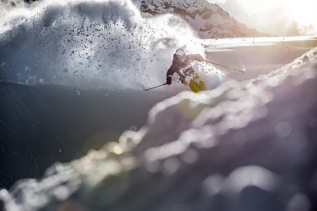 Young male skier riding through deep powder snow apart the slope, Andermatt, Uri, Switzerland