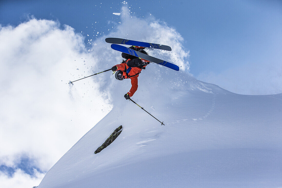 Young male skier jumping in the deep powder snow apart the slopes, Andermatt, Uri, Switzerland