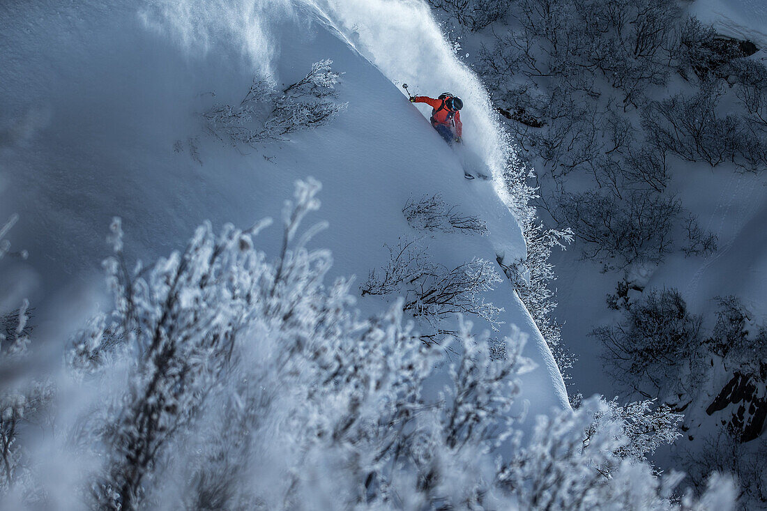 Young male skier riding through deep powder snow apart the slope, Andermatt, Uri, Switzerland