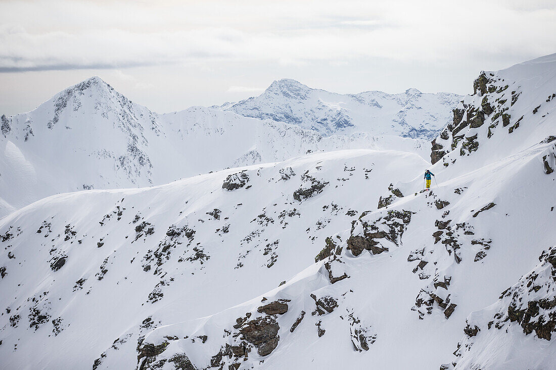 Young male skier standing in the deep powder snow apart the slopes, Andermatt, Uri, Switzerland