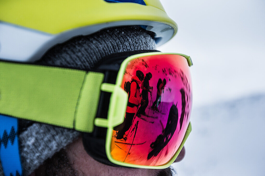 Reflexion von drei Skifahrern in einer Skibrille, Andermatt, Uri, Schweiz