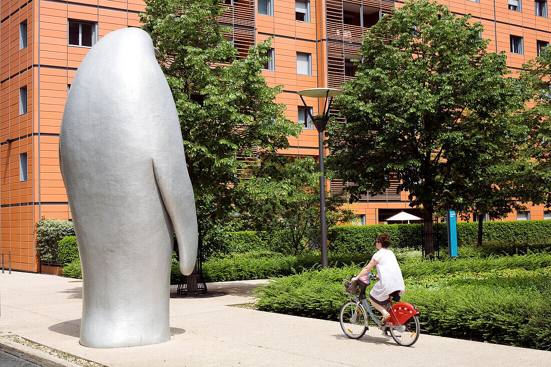 France, Rhone, Lyon, the Cite Internationale designed by the architect Renzo Piano, Velo'v bike passing by a sculpture by Xavier Veilhan showing a Penguin
