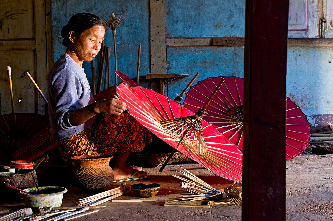 Myanmar (Burma), Shan State, Pindaya, family business manufacturing umbrellas U Ohn Khing, Daw Nyo Ohn U Khing completing the painting of paper