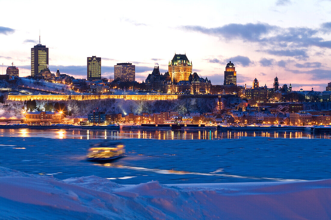 Canada, Quebec Province, Quebec City, Old Town listed World Heritage by UNESCO, panorama by night from Saint Lawrence River bank, Chateau Frontenac and Petit Champlain District, ferry in the ice