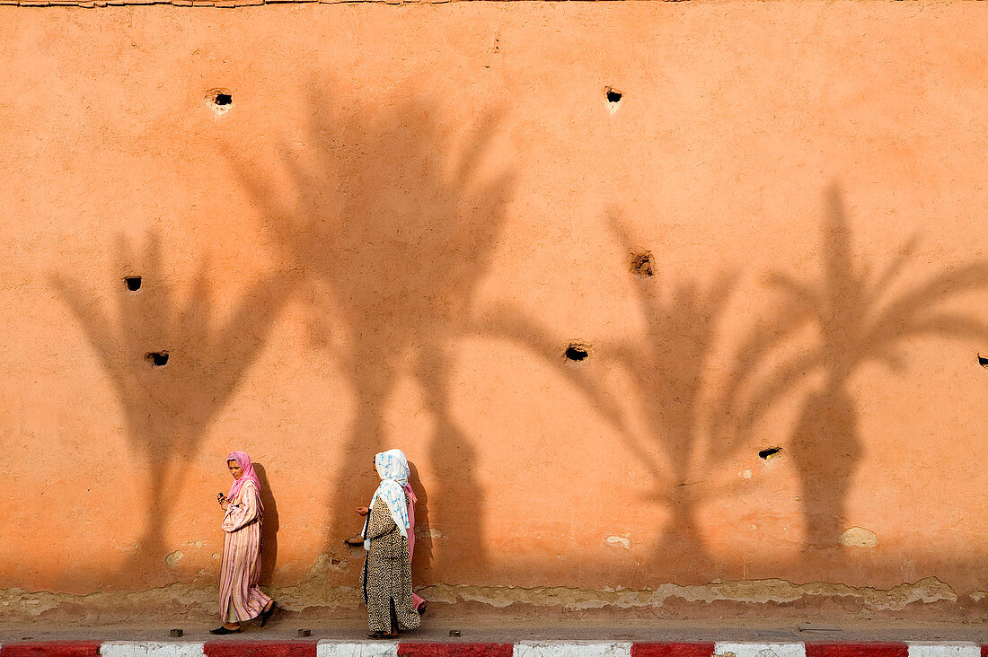 Morocco, Haut Atlas, Marrakesh, Imperial city, Medina listed as World Heritage by UNESCO, women walking by the Almoravide wall and palm trees shadow