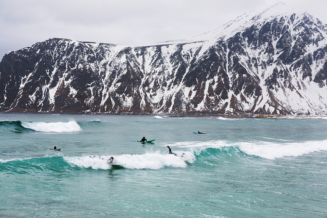 Surfer bei Flakstad, Berg Hustinden im Hintergrund, Flakstadoya, Lofoten, Norwegen, Skandinavien, Europa