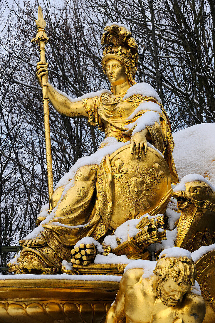 France, Yvelines, snow covered park of the Chateau de Versailles, listed as World Heritage by UNESCO, detail of a statue of the Triumphal Arch Grove