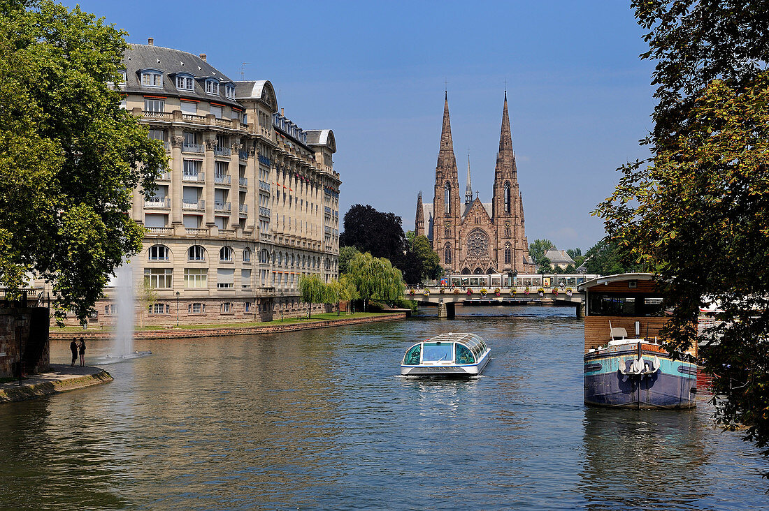 France, Bas Rhin, Strasbourg, old town listed as World heritage by UNESCO, River boat on Ill River, with St Paul Church in the background