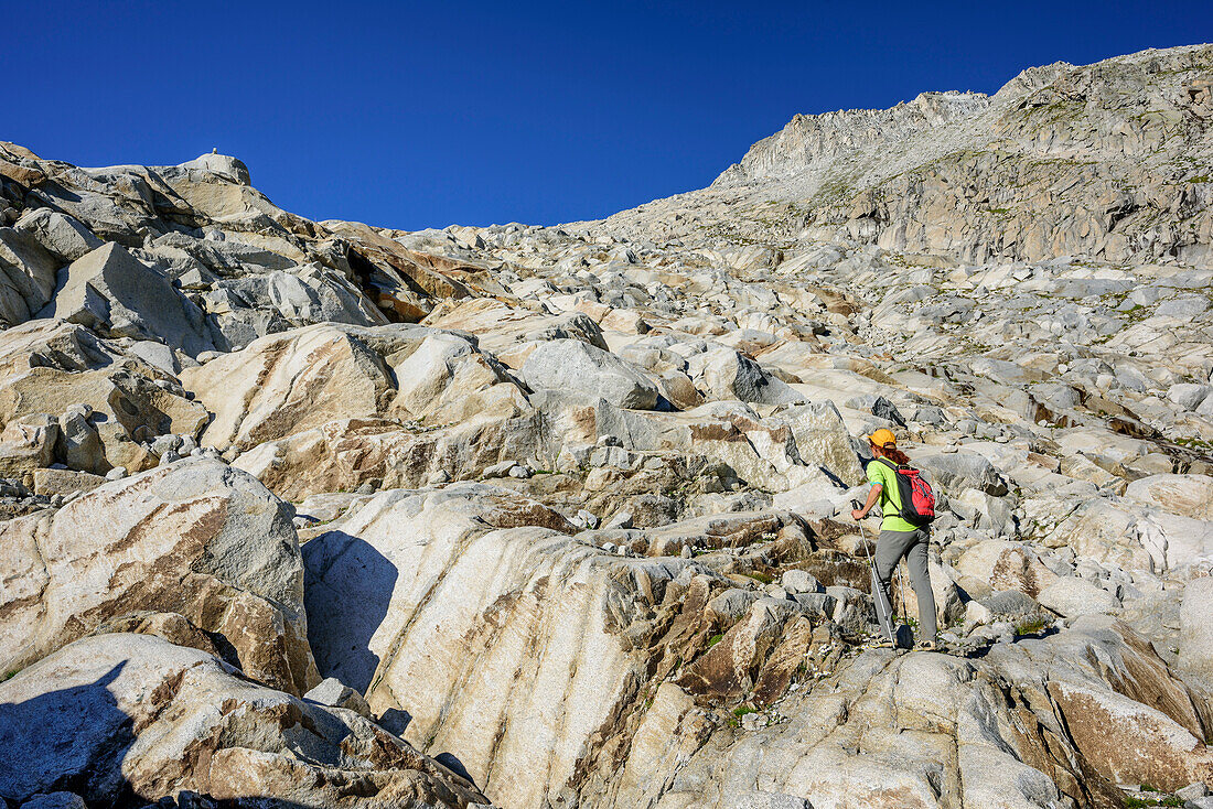 Frau steigt über Gletscherschliff zur Hütte Rifugio Lobbia Alta ai Caduti dell' Adamello auf, Rifugio Lobbia Alta, Val Genova, Adamello-Presanella-Gruppe, Trentino, Italien