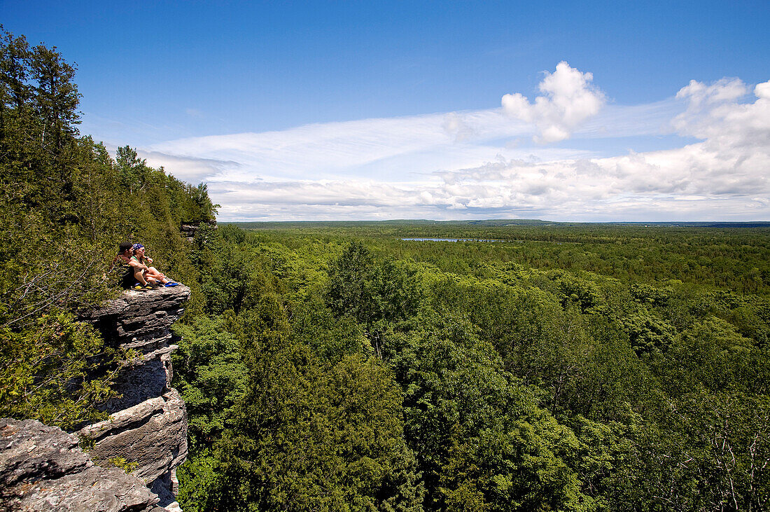 Canada, Ontario Province, Manitoulin Island, hiking at Cup and Saucer, couple at the edge of a cliff admiring the view