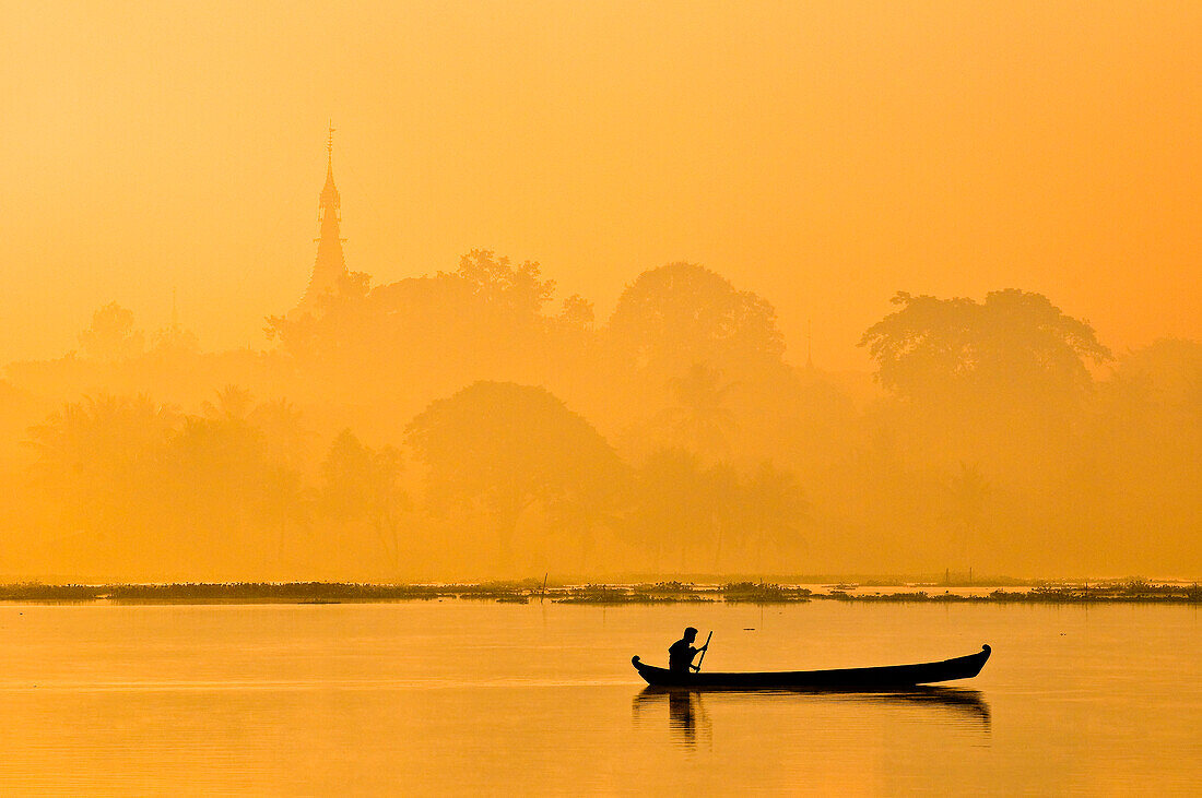 Myanmar (Burma), Mandalay Division, Amarapura, fisherman on lake Kan Daw Gwi with Pahtodaw Pagoda in the background