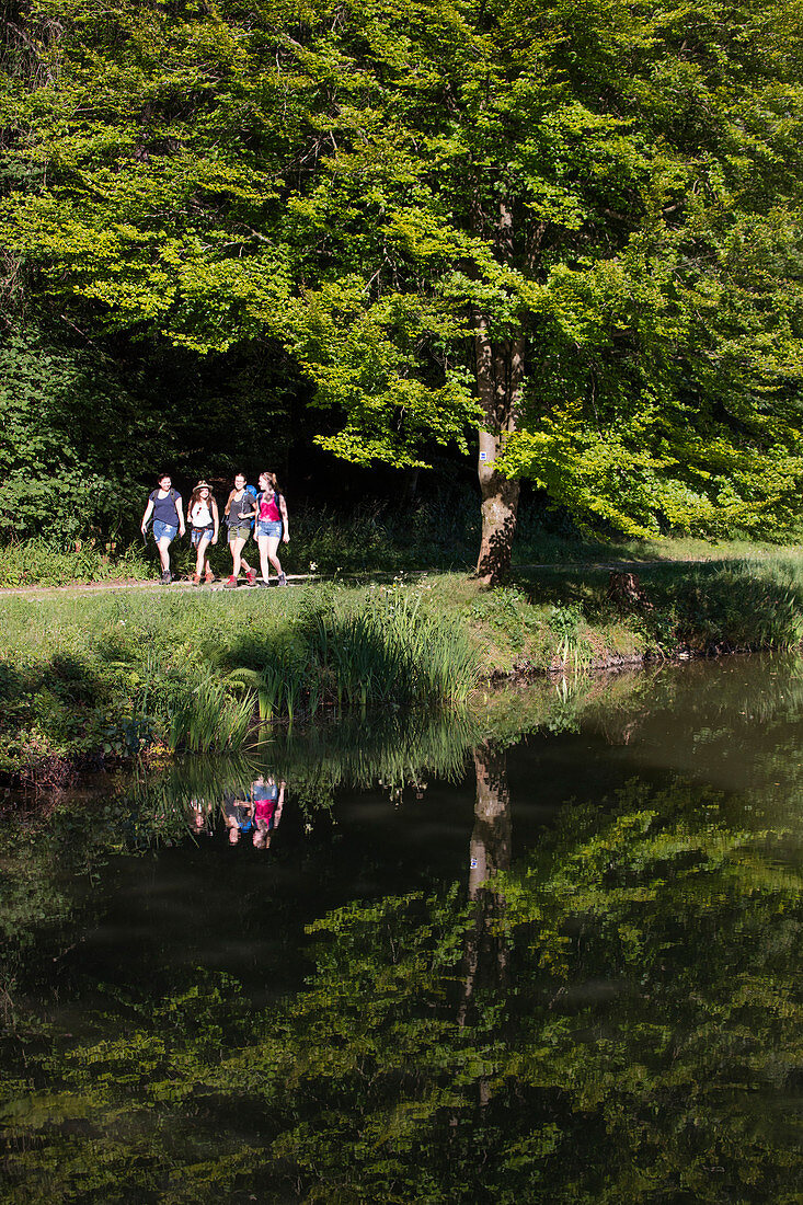 Vier junge Frauen wandern entlang der Aubachseen, Habichsthal, Spessart-Mainland, Bayern, Deutschland