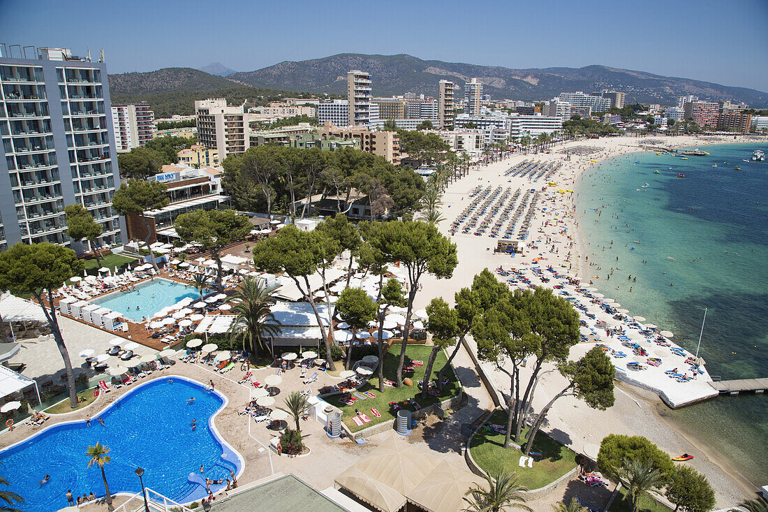 Overhead of hotel swimming pool and Playa de Magaluf beach, Magaluf, Mallorca, Balearic Islands, Spain