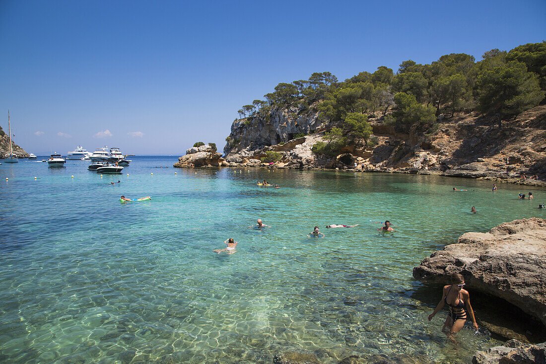 People swim, play and relax in water at beach in Cala Portals Vells bay, Portals Vells, Mallorca, Balearic Islands, Spain
