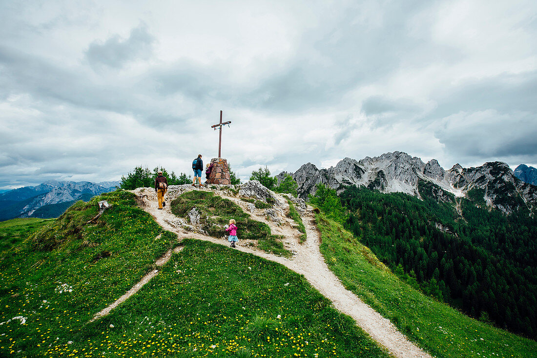 People climbing hill to crucifix, Tarvisio, Vienna, Austria
