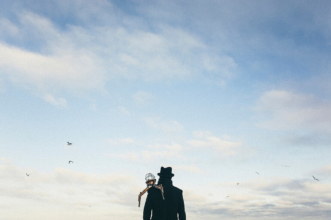 Drone on shoulder of man watching birds fly