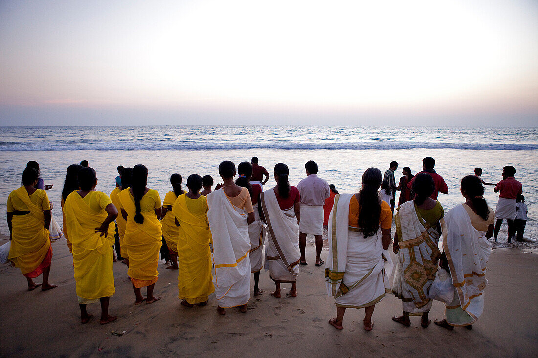 India, Kerala State, seaside resort of Varkala, on the beach the indians are watching the sun go down