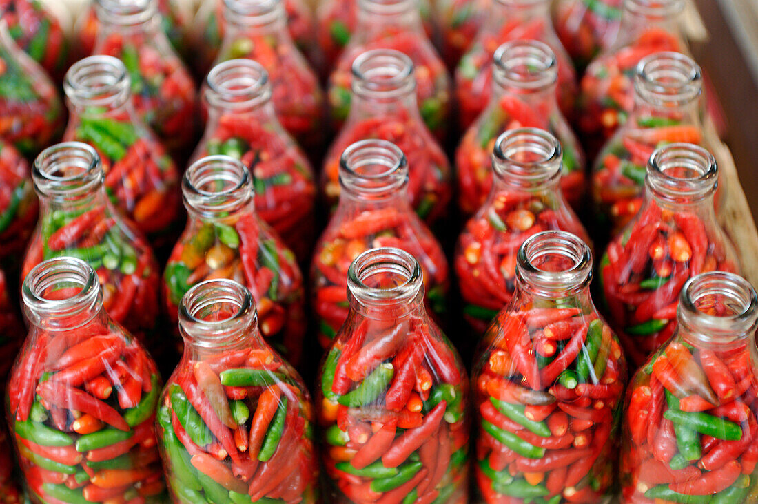 Brazil, Bahia State, Sao Joaquim Market, bottles of red and green chilis