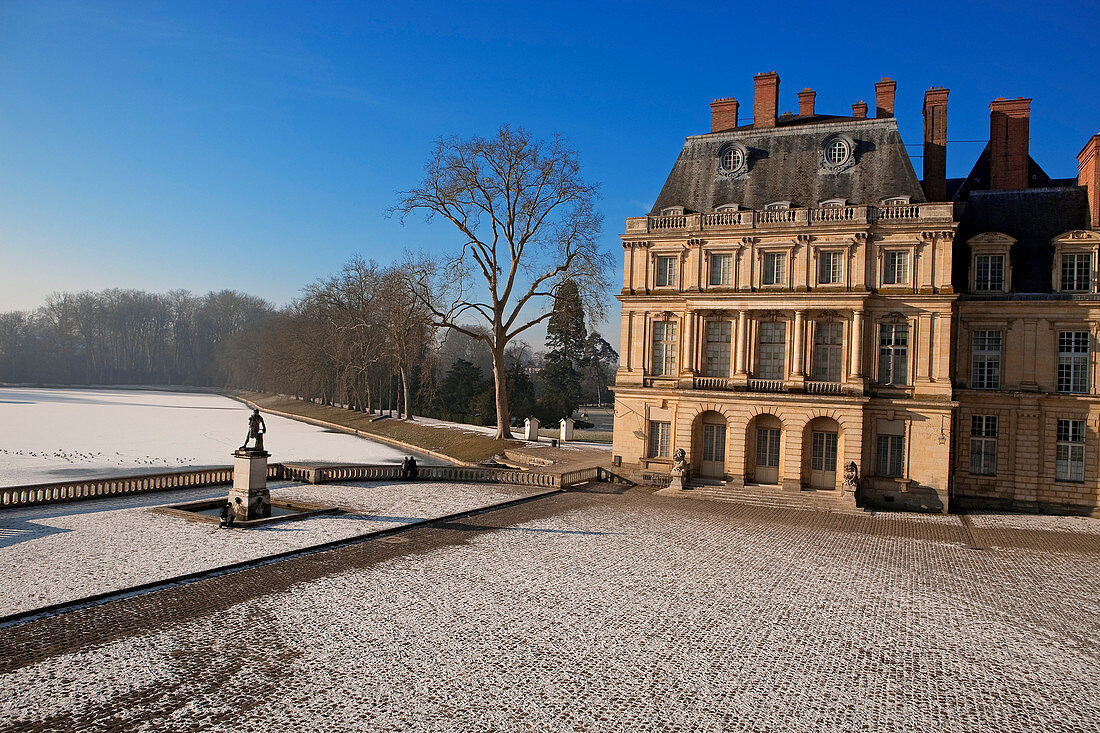 France, Seine et Marne, Fontainebleau, the Royal Castle, listed as World Heritage by UNESCO, the cour de la fontaine (courtyard of the fountain) and etang des carpes (carps pond) frozen under the snow