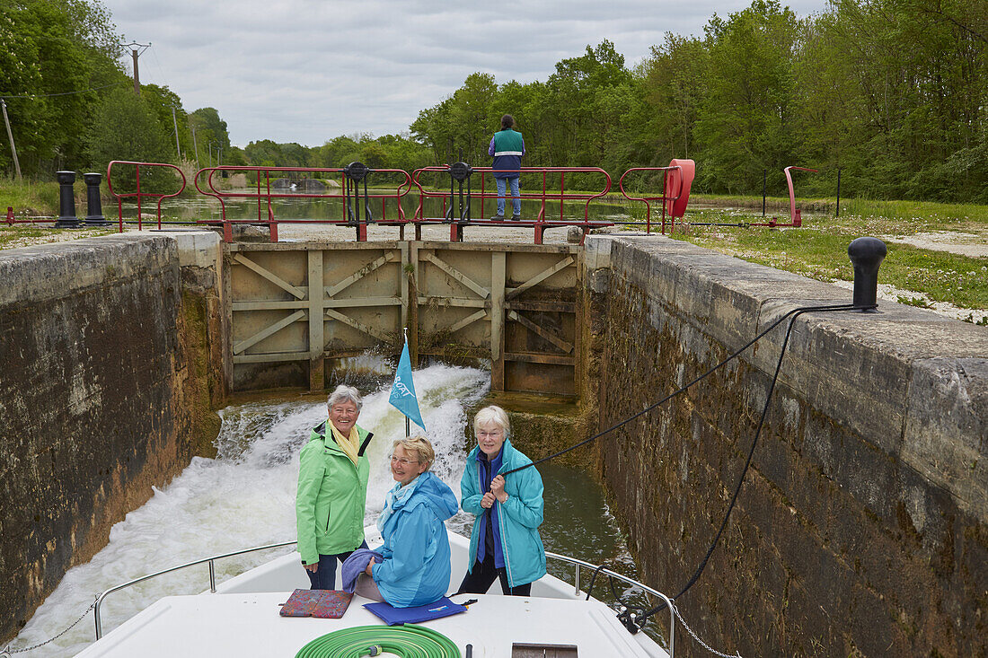 Members of the crew on a houseboat in lock no.101 Flogny on the Canal de Bourgogne , Departement Yonne , Burgundy , France , Europe