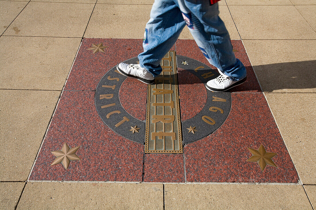 United States, Illinois, Chicago, Loop District, sign of Chicago District on a sidewalk and passer-by