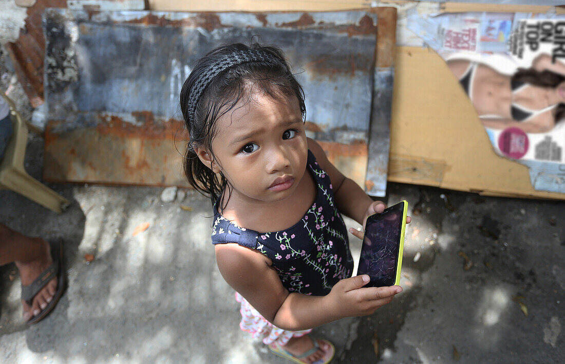 Street poverty, young girl with cellphone, Manila   Metro Manila