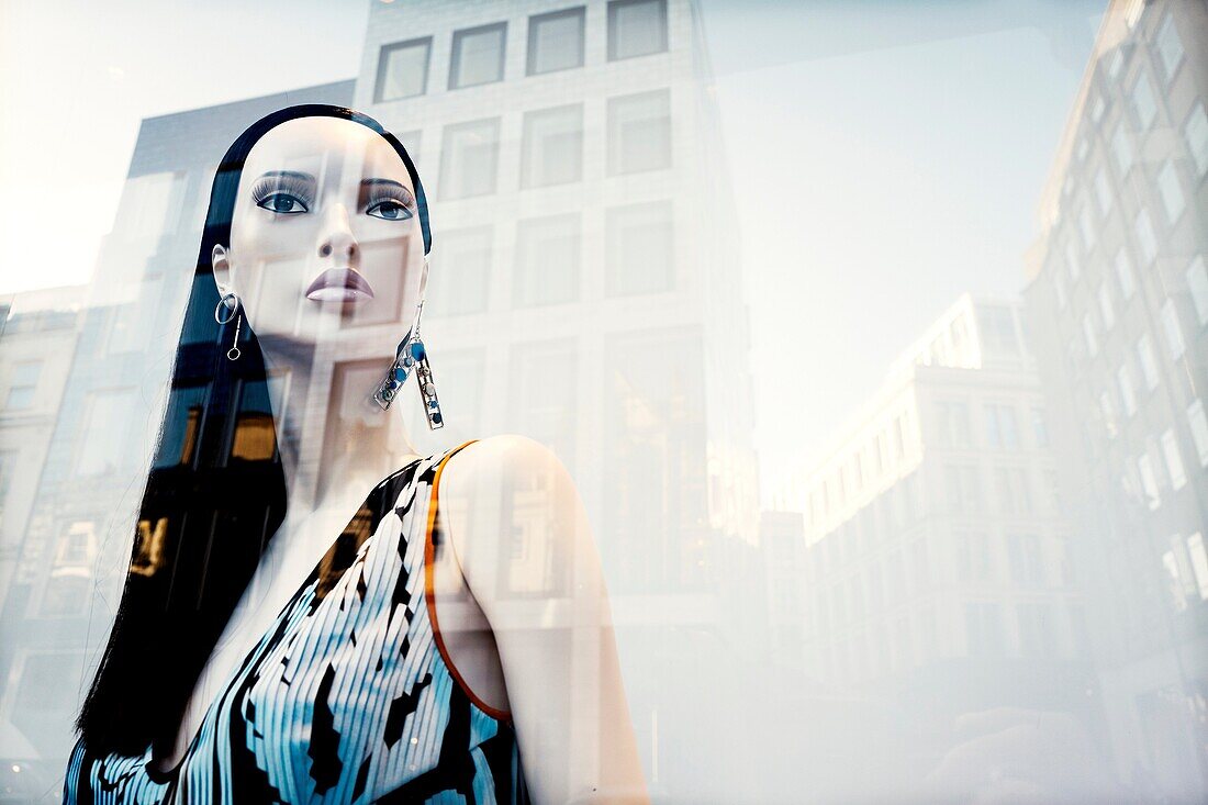 Female mannequin with elegant dress in shop window, fashion shop, reflections on the glass, London, England