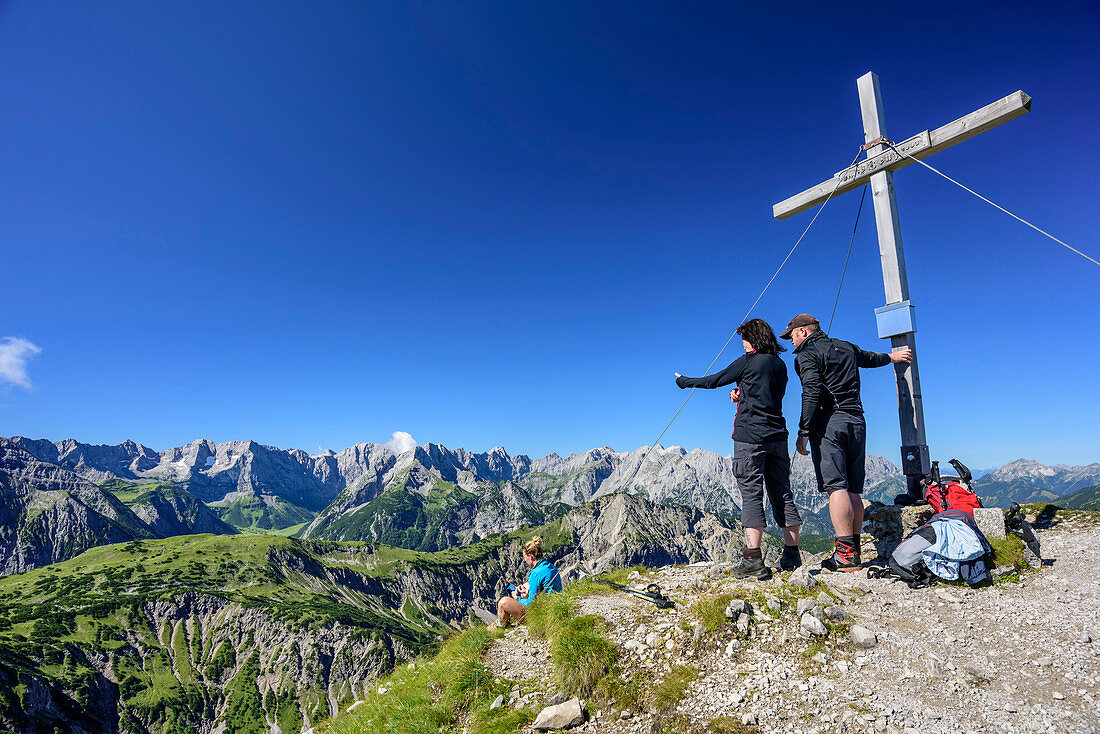 Drei Personen stehen am Gipfelkreuz der Mondscheinspitze, Karwendel im Hintergrund, Mondscheinspitze, Naturpark Karwendel, Karwendel, Tirol, Österreich