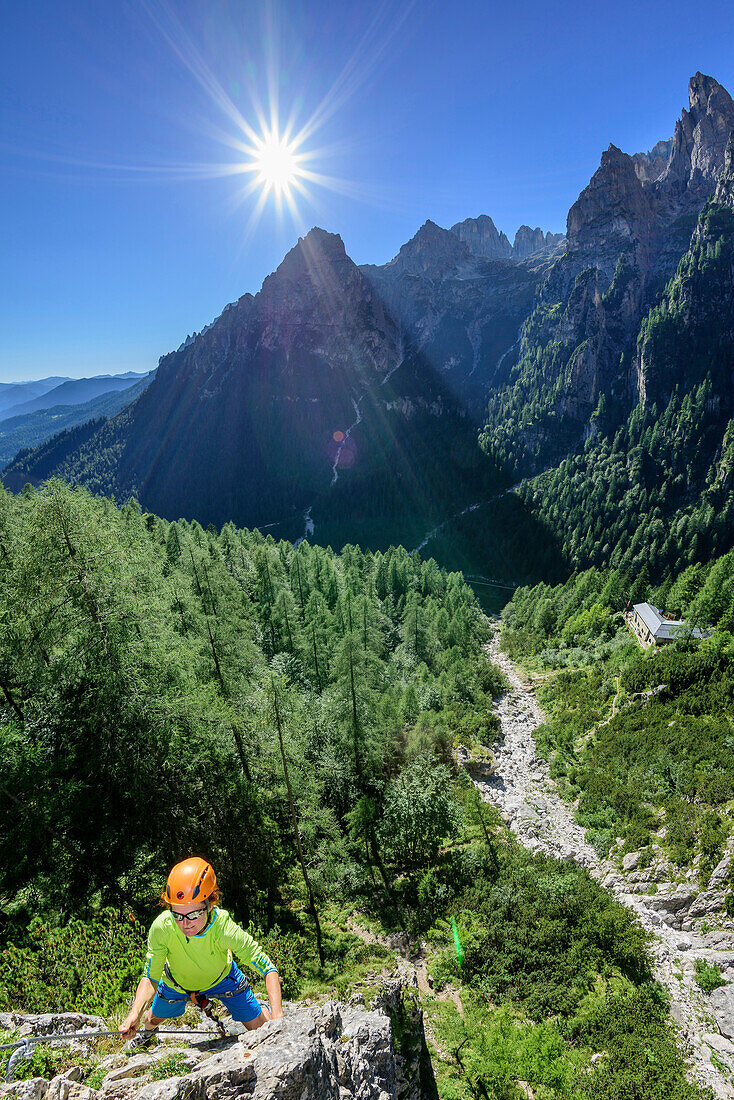 Frau begeht Klettersteig Canalone, Val Canali im Hintergrund, Val Canali, Pala, Dolomiten, UNESCO Weltnaturerbe Dolomiten, Trentino, Italien