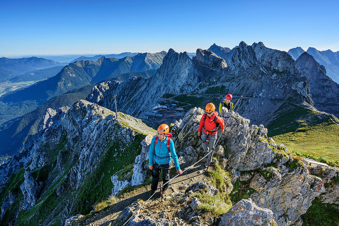 Drei Personen begehen Klettersteig Mittenwalder Höhenweg, Westliche Karwendelspitze im Hintergrund, Mittenwalder Höhenweg, Karwendel, Oberbayern, Bayern, Deutschland