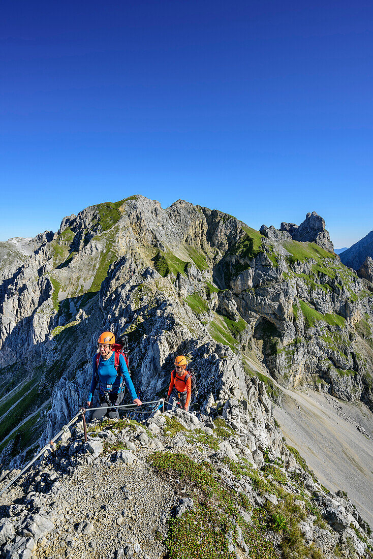 Two women climbing on fixed-rope route Mittenwalder Hoehenweg, fixed-rope route Mittenwalder Hoehenweg, Karwendel range, Upper Bavaria, Bavaria, Germany