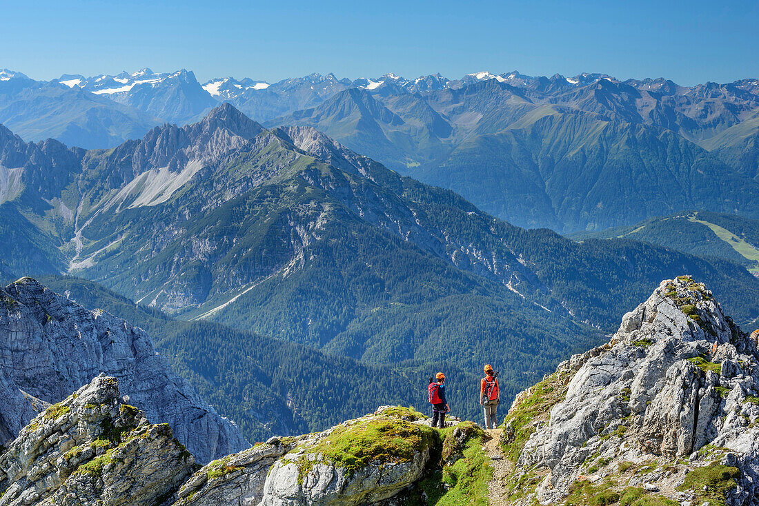 Two women climbing on fixed-rope route Mittenwalder Hoehenweg, Stubai Alps in background, fixed-rope route Mittenwalder Hoehenweg, Karwendel range, Upper Bavaria, Bavaria, Germany