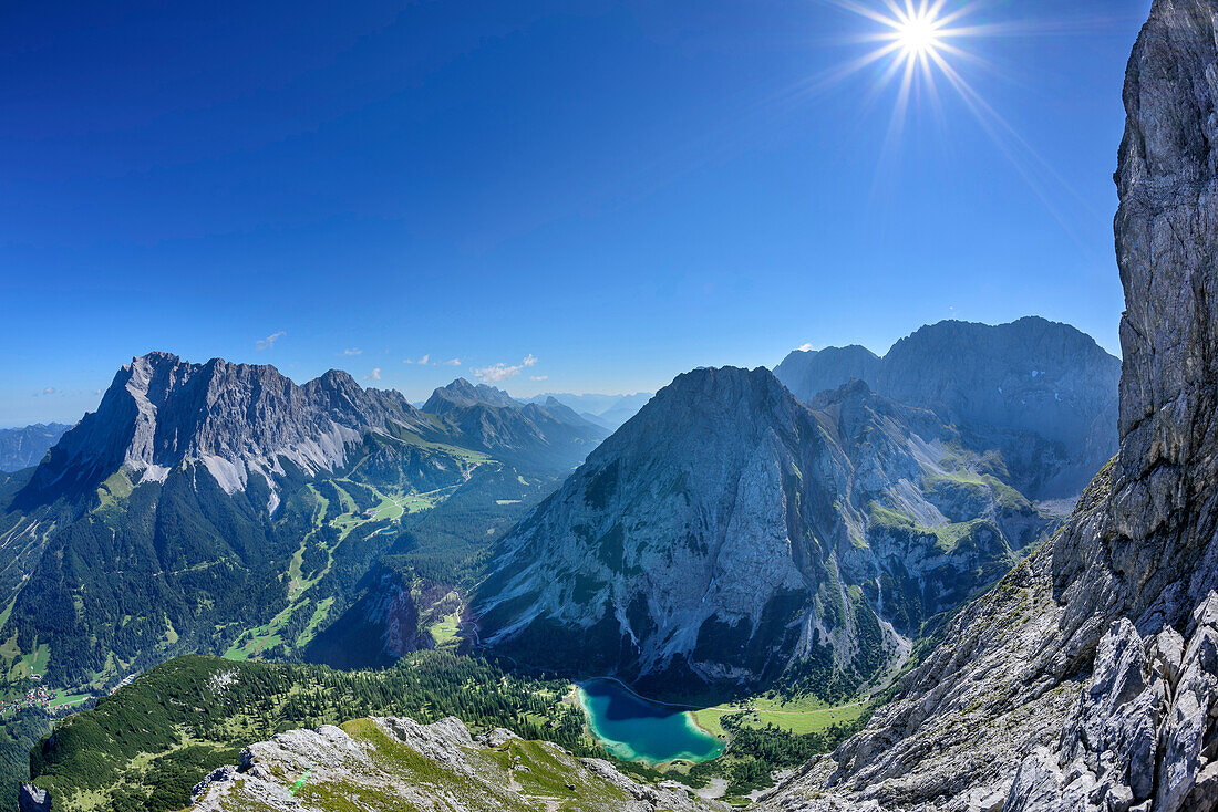 View towards Wetterstein range with Zugspitze and lake Seebensee, from Ehrwalder Sonnenspitze, Mieming range, Tyrol, Austria