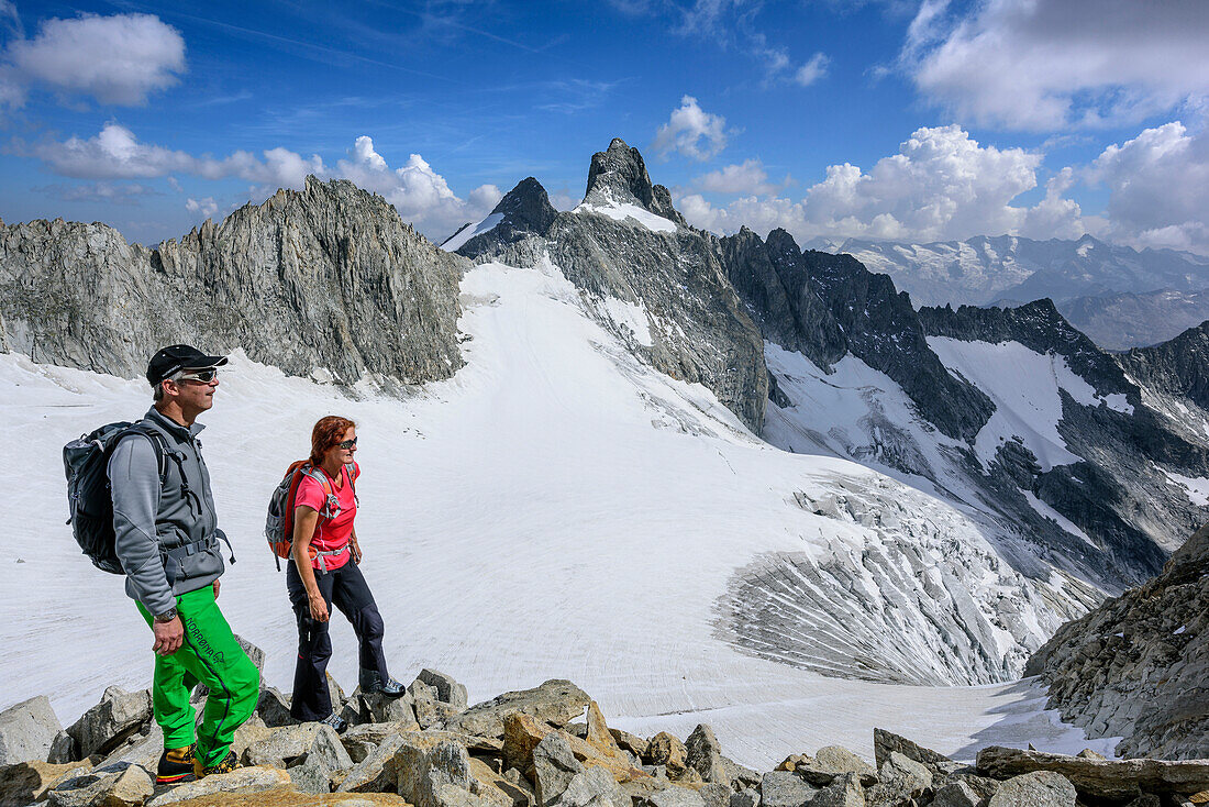 Man and woman ascending to Kuchelmooskopf, Reichenspitze and glacier Kuchelmoosferner in background, Kuchelmooskopf, Zillergrund, Reichenspitze group, Zillertal Alps, Tyrol, Austria