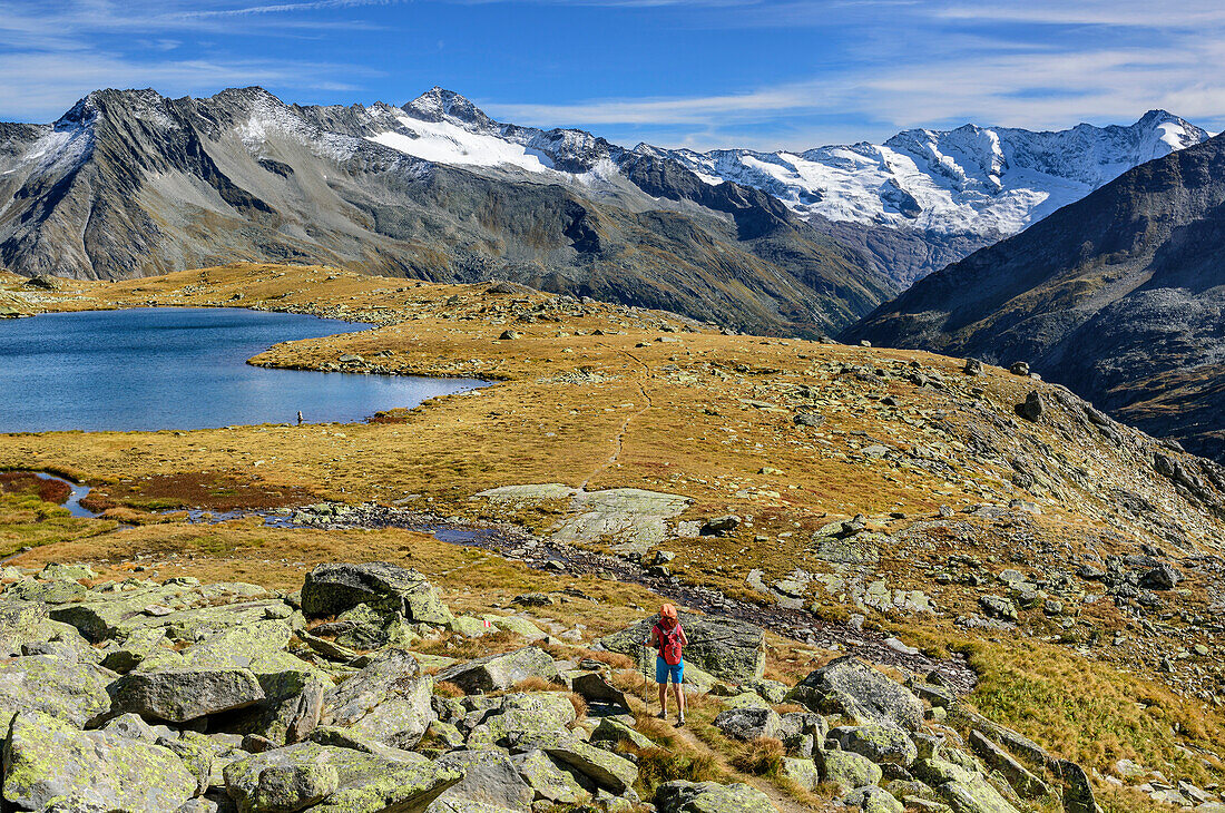 Frau beim Wandern geht auf Rainbachsee zu, Schlieferspitze und Dreiherrenspitze im Hintergrund, Naturpark Zillertaler Alpen, Dreiländertour, Zillertaler Alpen, Salzburg, Österreich