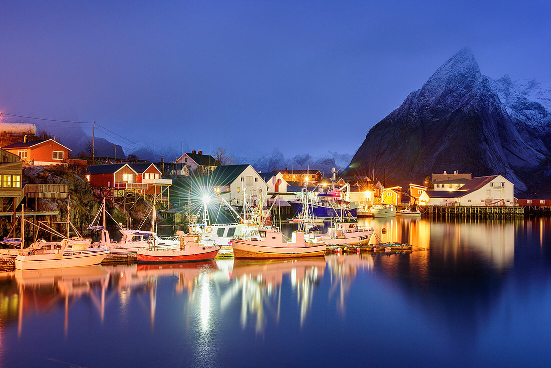 Bay with illuminated boats and houses of Hamnoy, Hamnoy, Lofoten, Norland, Norway