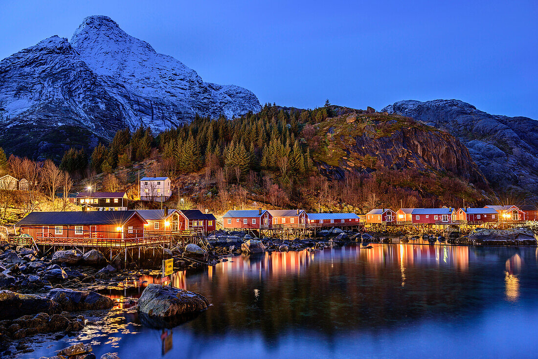 Meeresbucht mit beleuchteten Häusern von Nusfjord, Nusfjord, Lofoten, Norland, Norwegen