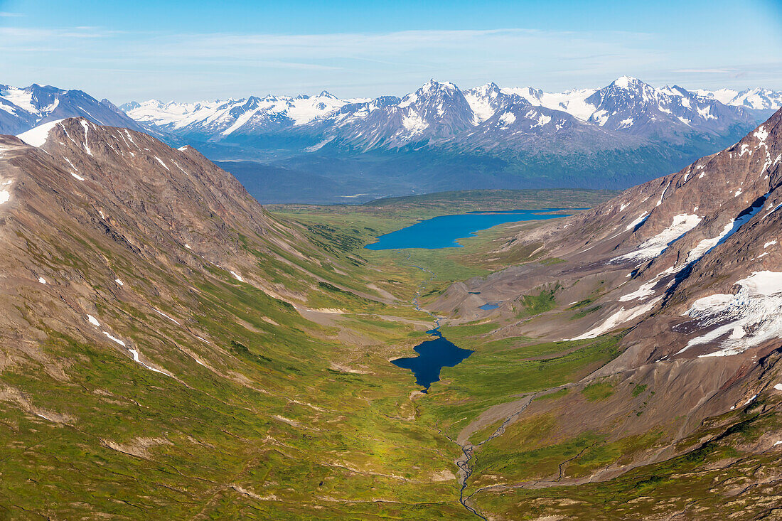 Aerial view of spring snow melting off the Kenai mountains on a clear summer day, Lost Lake in the valley below, Kenai Peninsula, Southcentral Alaska, Seward, Alaska, United States of America