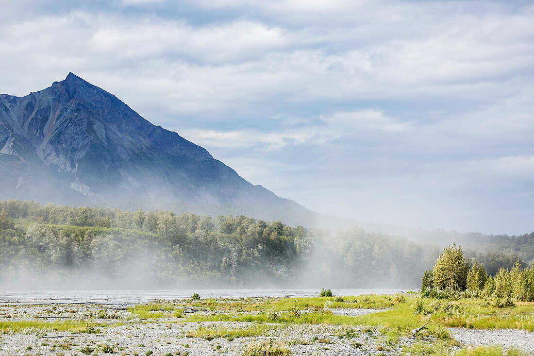 River silt being blown about Matanuska River bed on a windy and cloudy day, King Mountain in the background, south, central Alaska in summertime, Palmer, Alaska, United States of America