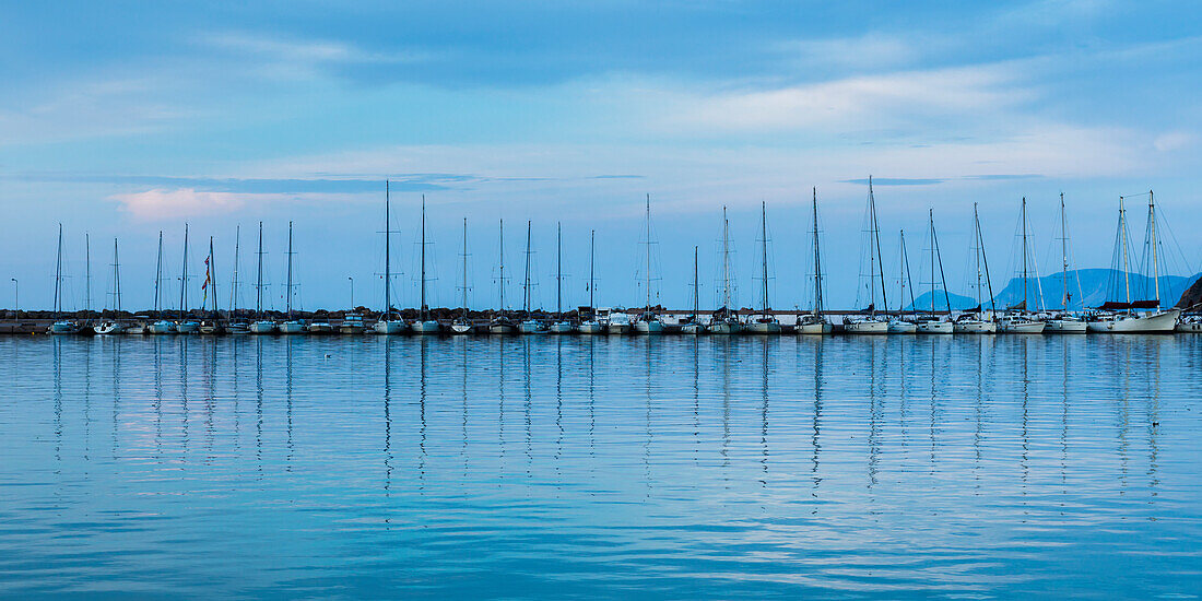 Sailboats moored in a row along a pier in a harbour, Skopelos Town, Skiathos, Greece