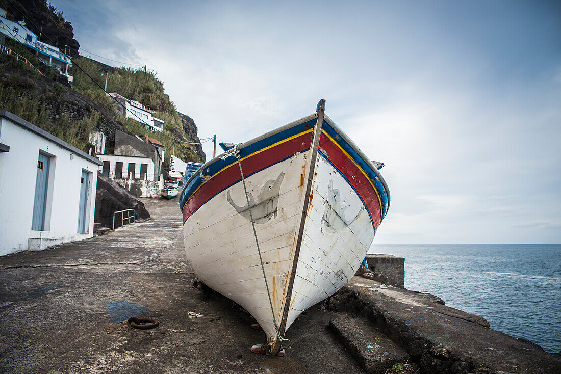 Fishing boat on the shore at the water's edge, Ponta do Arnel, Sao Miguel, Azores, Portugal