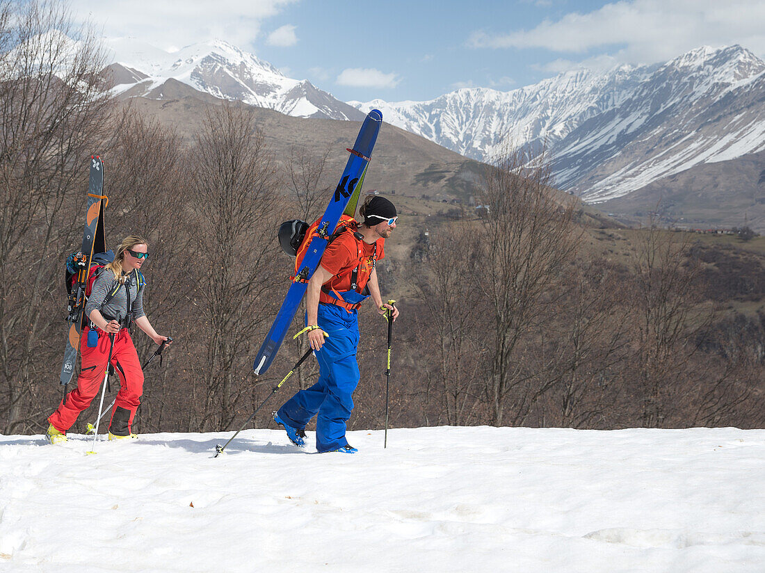 Zwei junge Skifahrer steigen einen Berg hinauf, Gudauri, Mzcheta-Mtianeti, Georgien