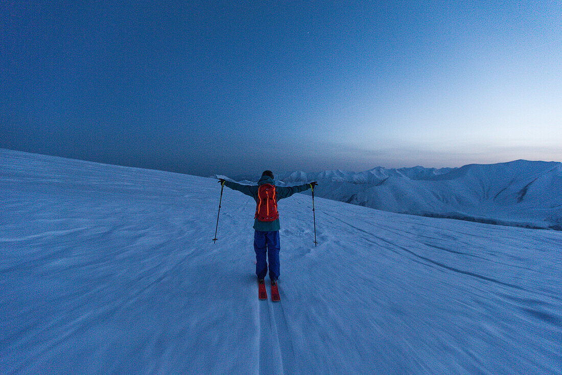 Junger Skifahrer fährt in der Abenddämmerung einen Berg herunter/ Gudauri, Mzcheta-Mtianeti, Georgien