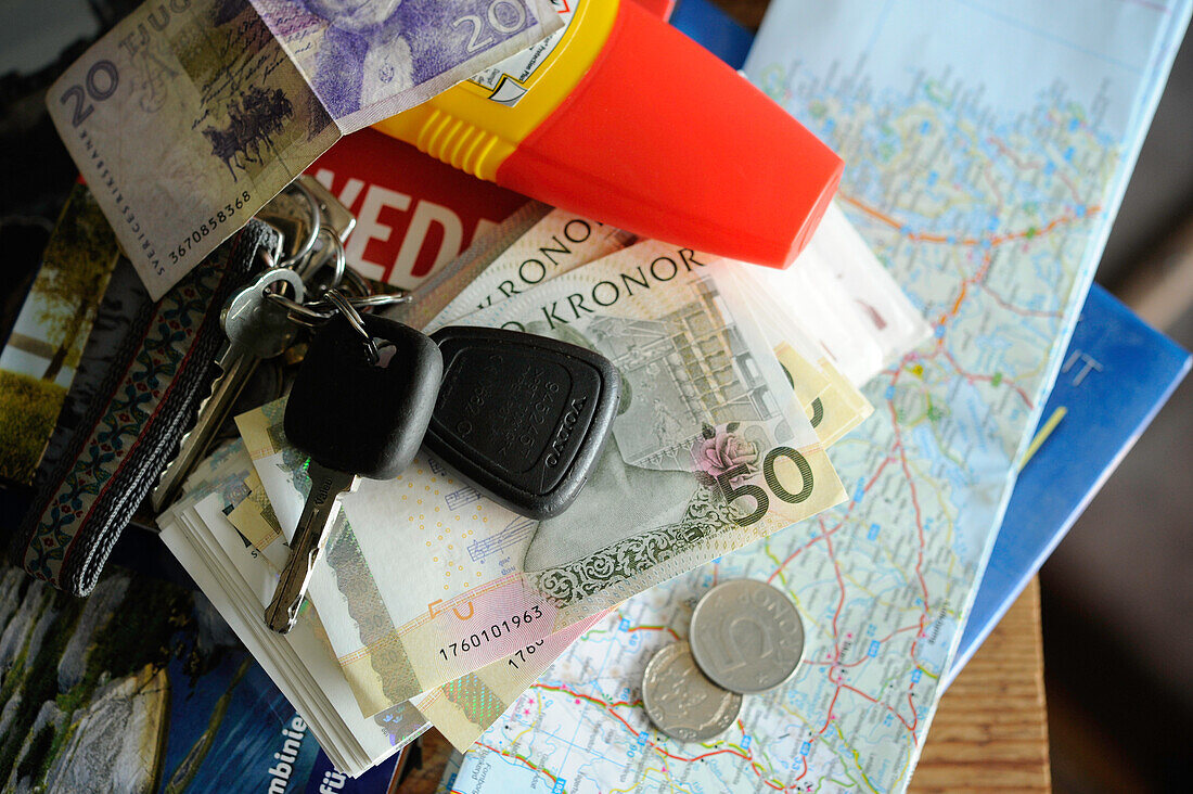 Still auf dem Tisch mit Autoschlüssel, schwedischem Geld und Landkarte, Reisen