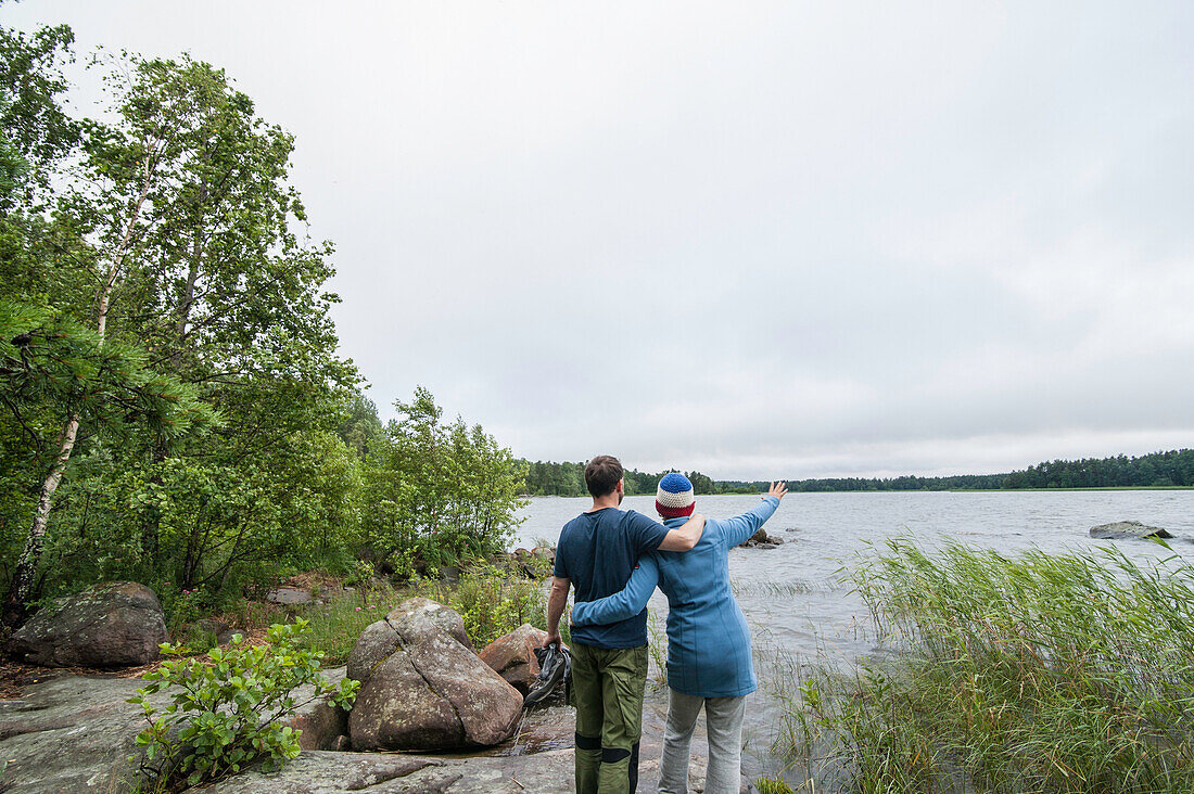 couple standing on the shore and looking across lake vanern, Smaland, Sweden