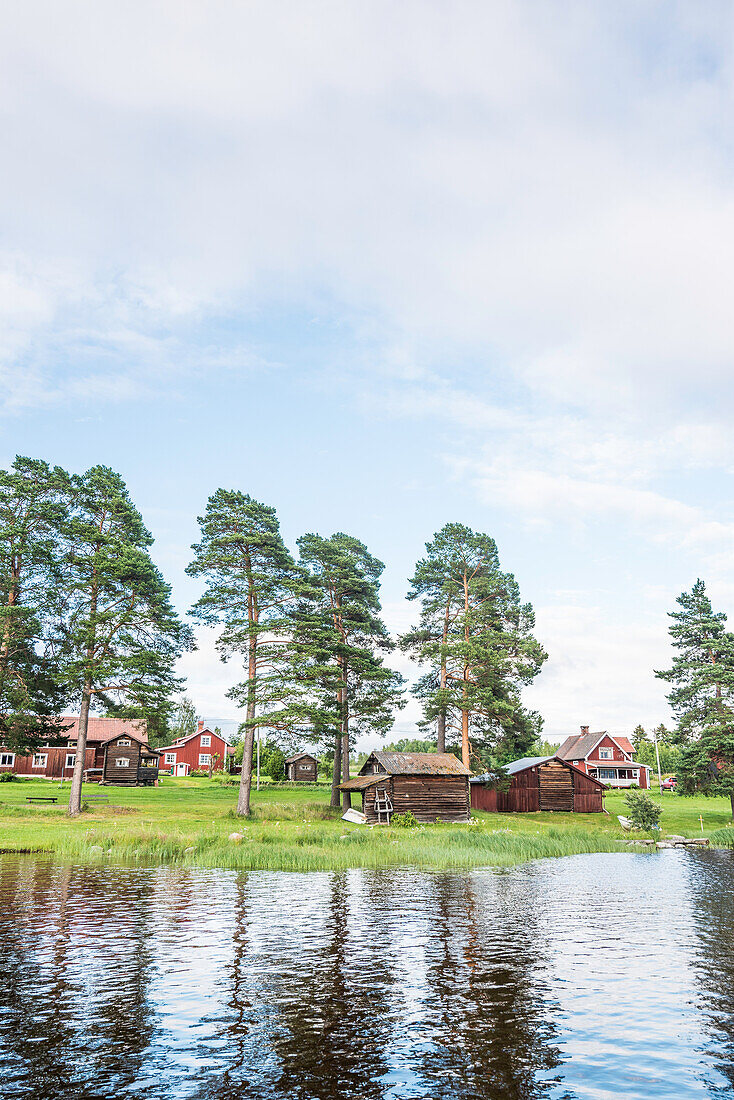 view from water to the village of with its red wooden houses, Solleron, Dalarna, Sweden