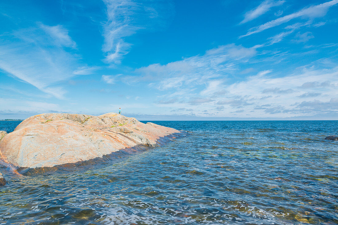 Kind läuft über einen großen Felsen im Meer, Öregrund, Bottensee, Uppsala, Schweden