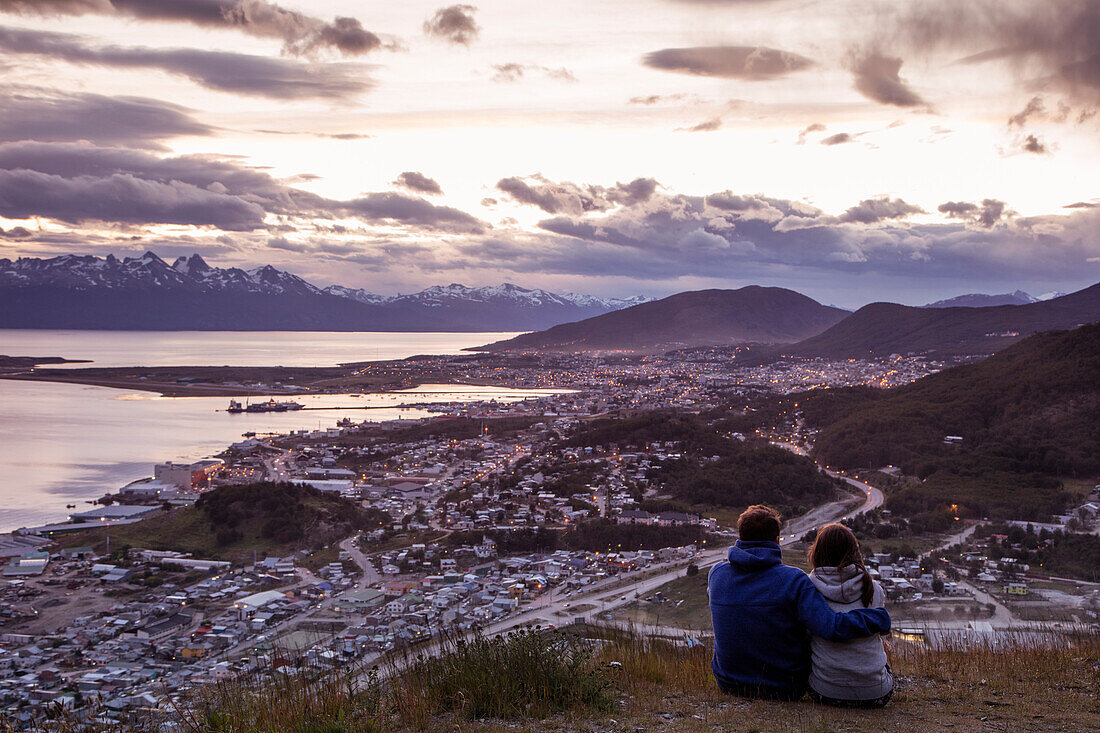 Couple overlook city from Arakur Ushuaia Resort and Spa at sunset Ushuaia, Tierra del Fuego, Patagonia, Argentina
